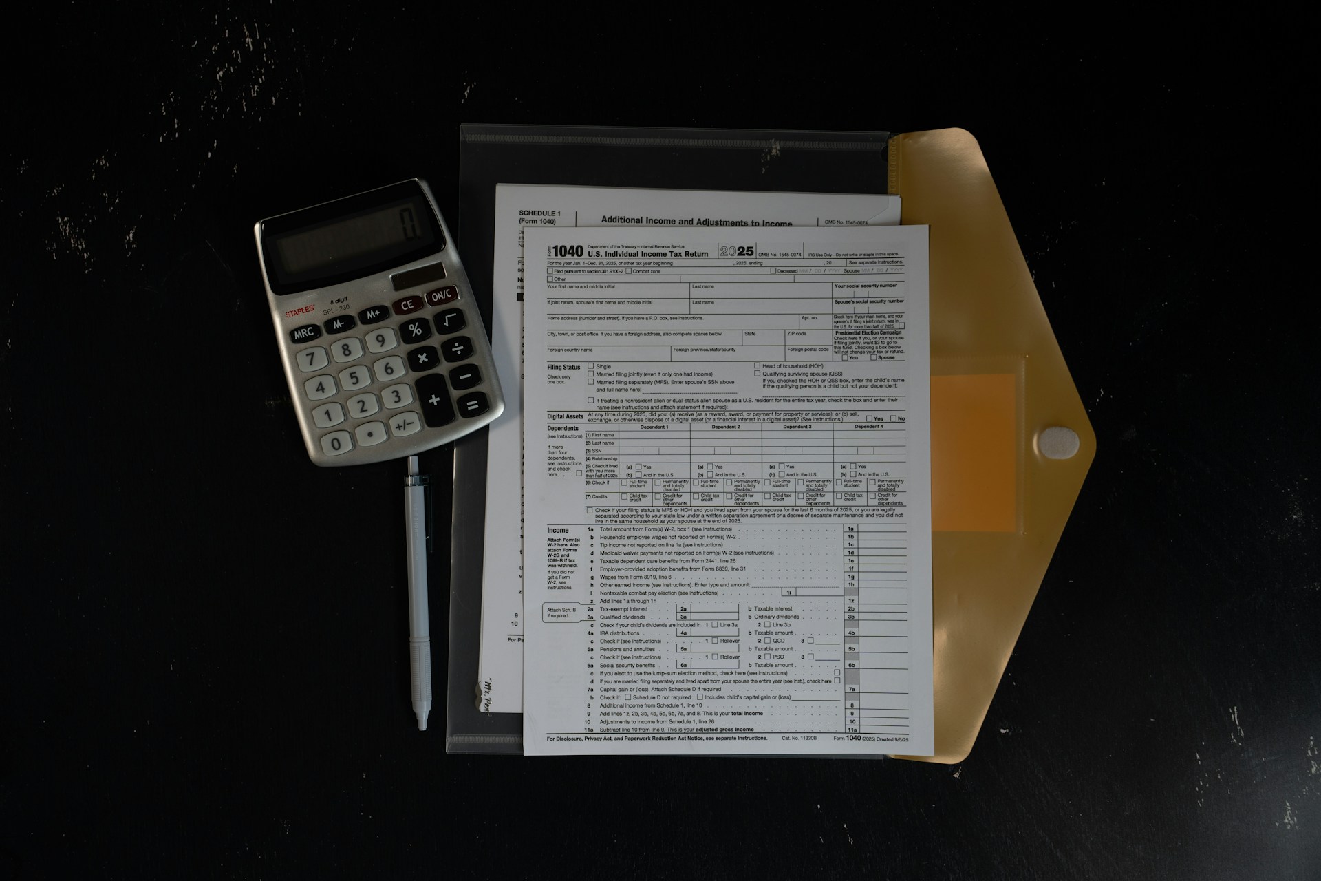 Tax return form with calculator and pen on a desk